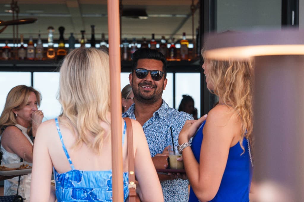 Guests talking over drinks at the rooftop bar at Retreat